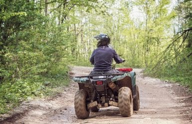 Man op een quad in het bos