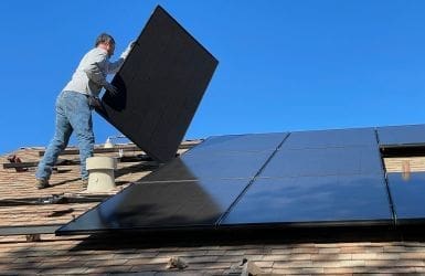 panele słoneczne budynek biznesowy człowiek dach
