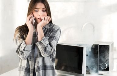 woman on phone, microwave smokes in background
