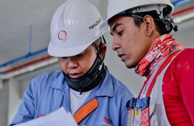 workmen look at a building plan