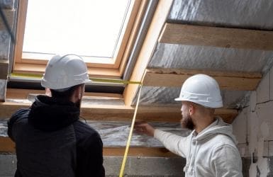 Construction workers measure a window