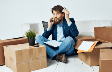 Man sitting phone with boxes