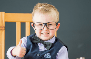 Child with glasses on chair