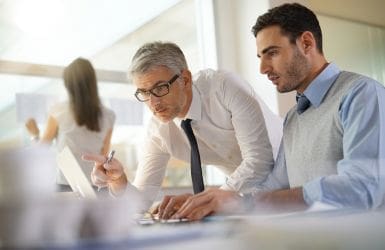 two business partners behind a laptop