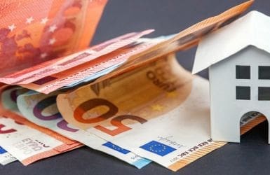 Euro biljetten naast houten huisje