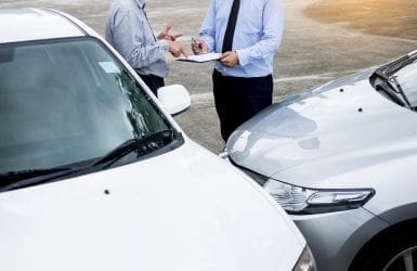 twee mannen vullen een formulier in na een auto-ongeluk