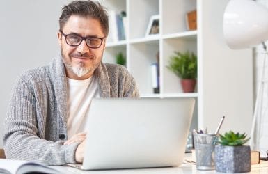 man behind laptop at home