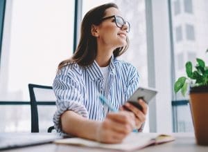 vrouw met smartphone en notitieblok