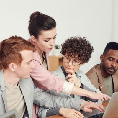 people in office behind laptop